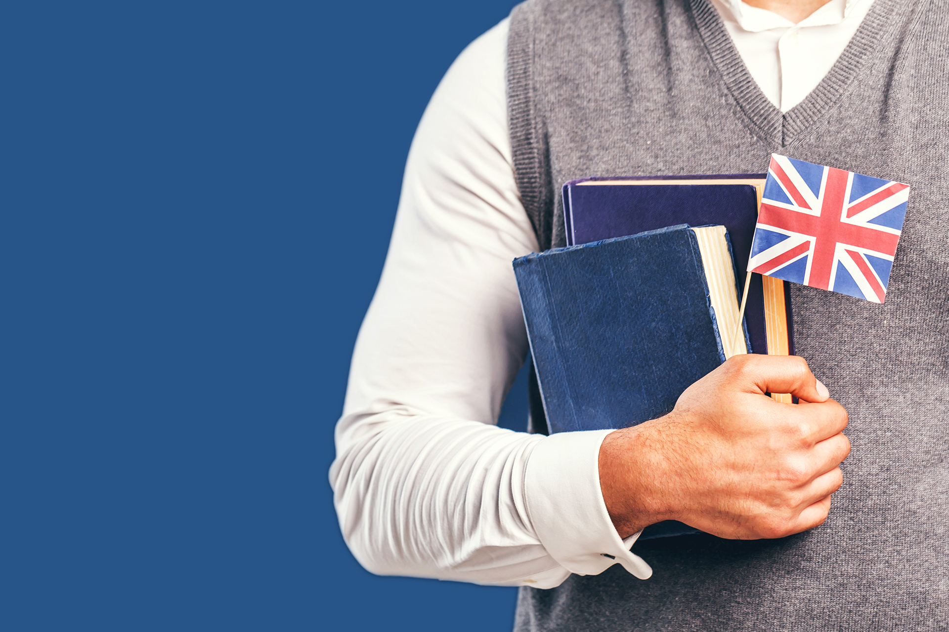 Man,Wears,Grey,Sweater,Vest,Holds,English,Books,And,Flag