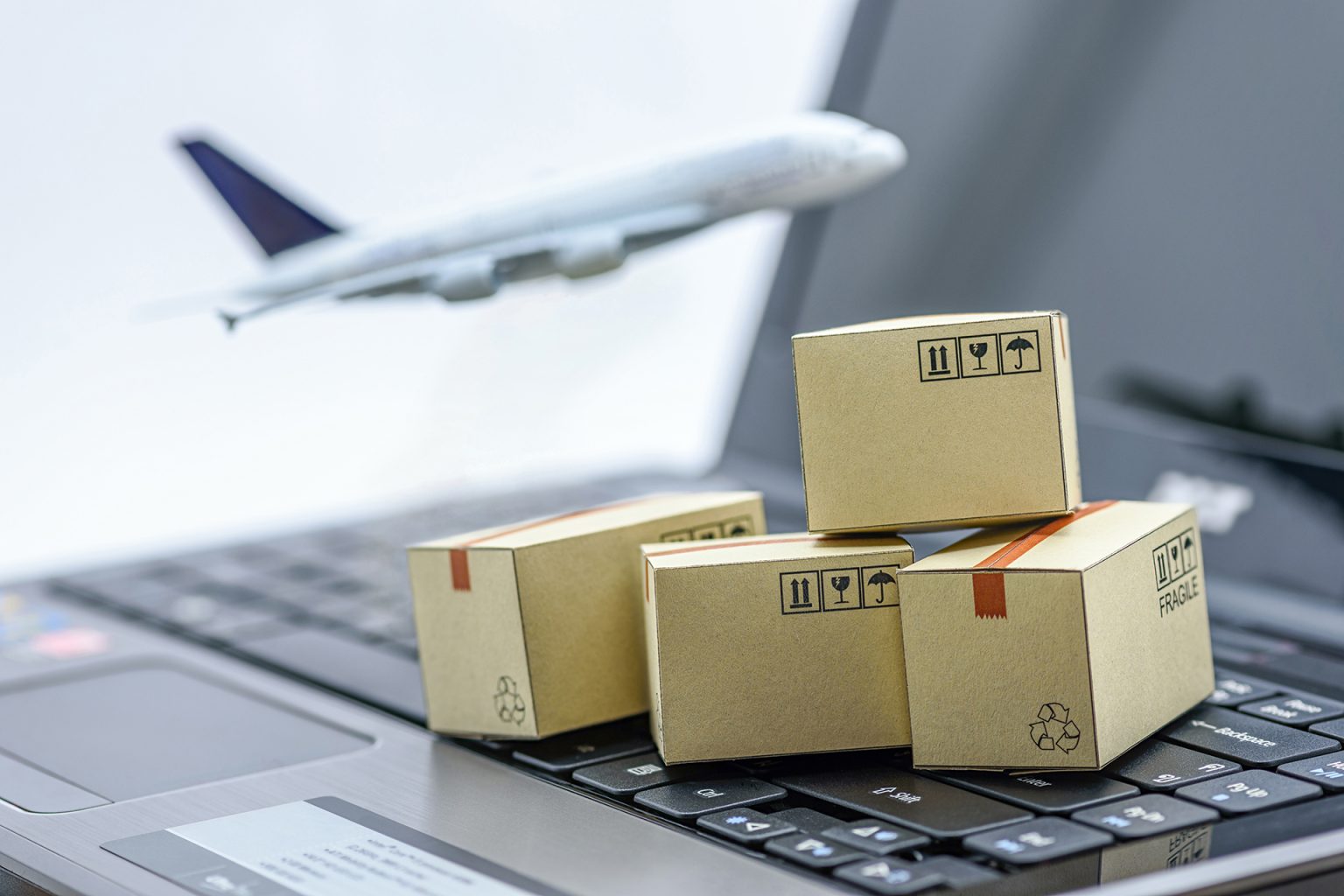 Mini,Cardboard,Boxes,On,A,Laptop,With,A,Plane,Flies